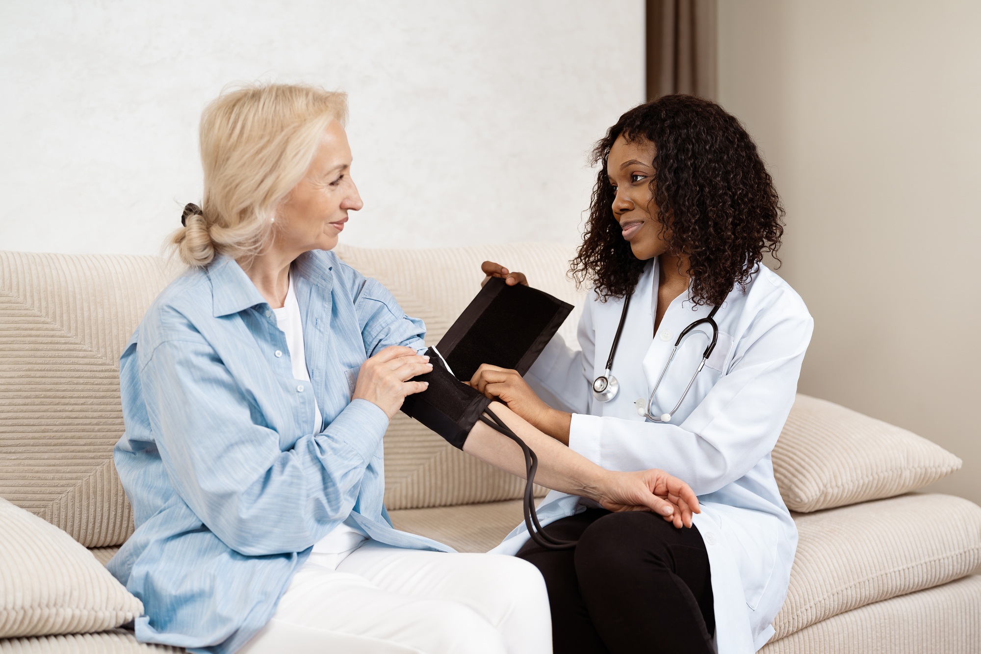 Doctor Checking Elderly Woman's Blood Pressure During Home Visit